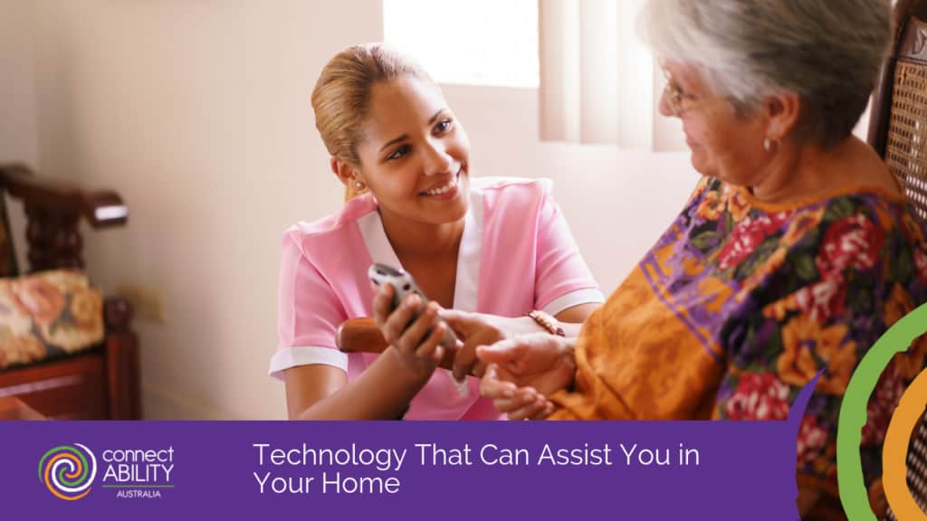 A young caregiver in a pink uniform showing an elderly woman how to use a mobile phone