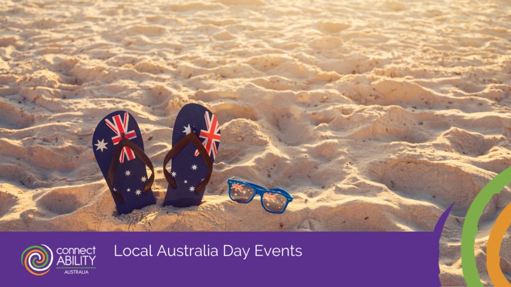 A pair of flip-flops and sunglasses featuring the Australian flag resting on a sandy beach