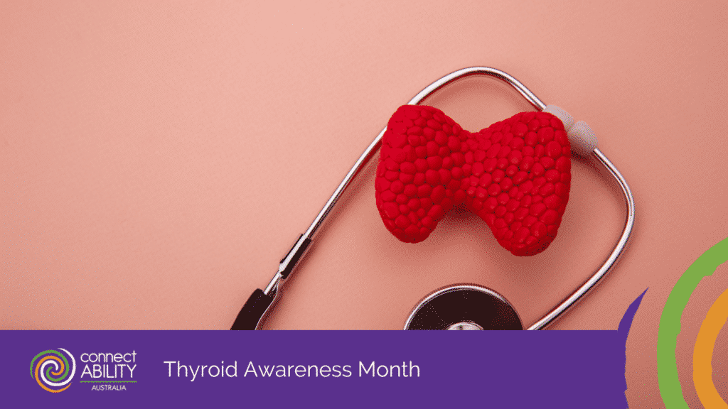 A red, textured model of a thyroid gland resting inside the loop of a stethoscope