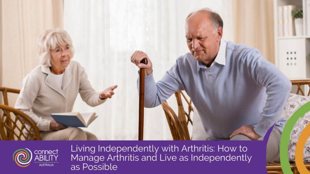 An elderly man wincing in discomfort while using a cane to stand up, as a woman watches with concern in the background