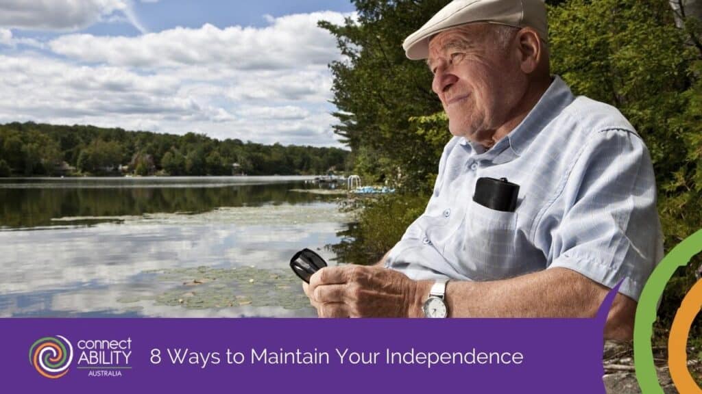 An elderly man in a flat cap sitting peacefully by a calm lake