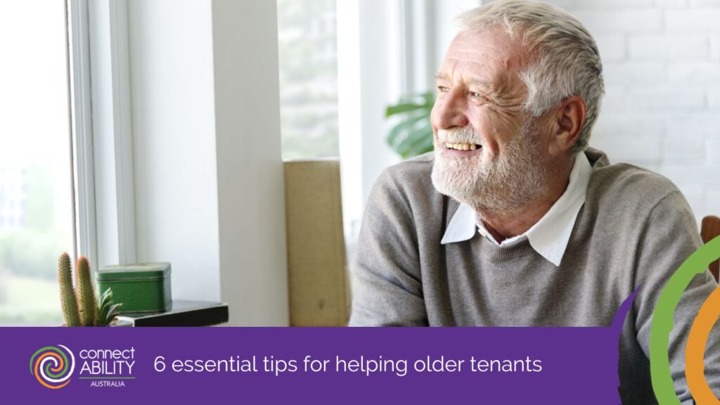 A smiling elderly man with a gray beard looking out a window