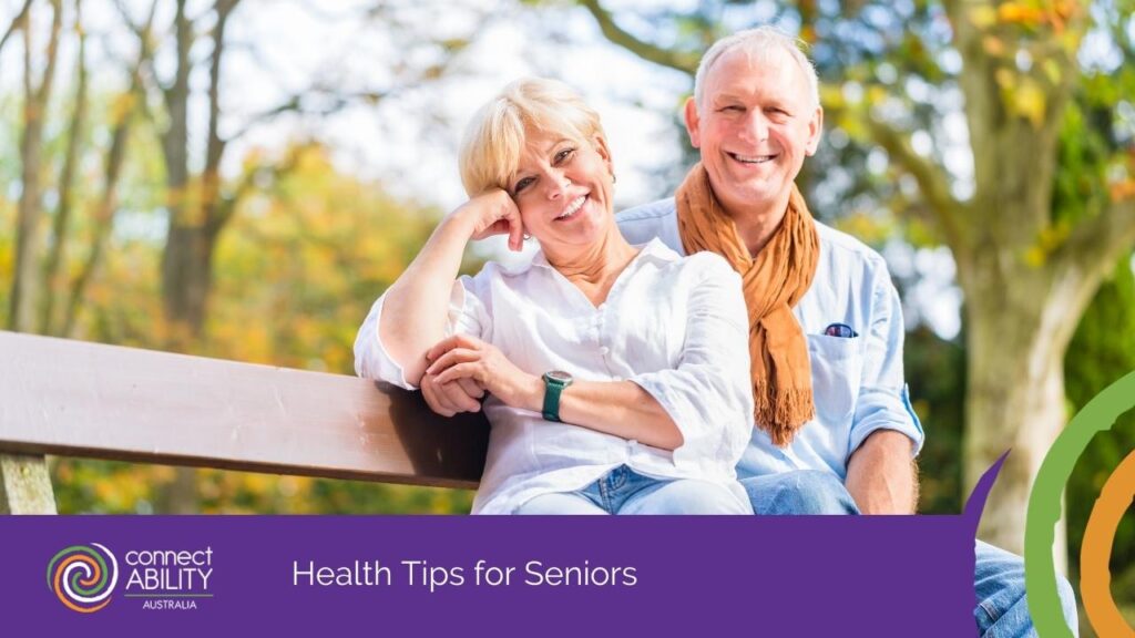 A smiling elderly couple sitting together on a wooden park bench outdoors